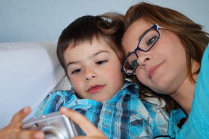 Mutter mit Sohn kuschelnd auf der Couch